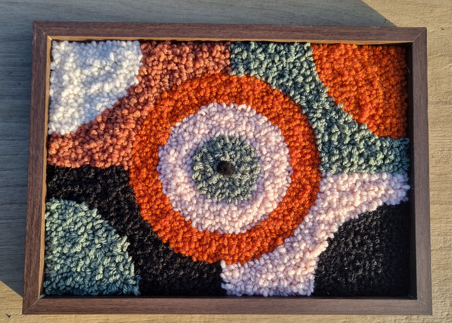 Wall hanging made with punch needle or tufting wool, warm tones of beige, brown, and orange. One-of-a-kind piece, 23 × 31 cm