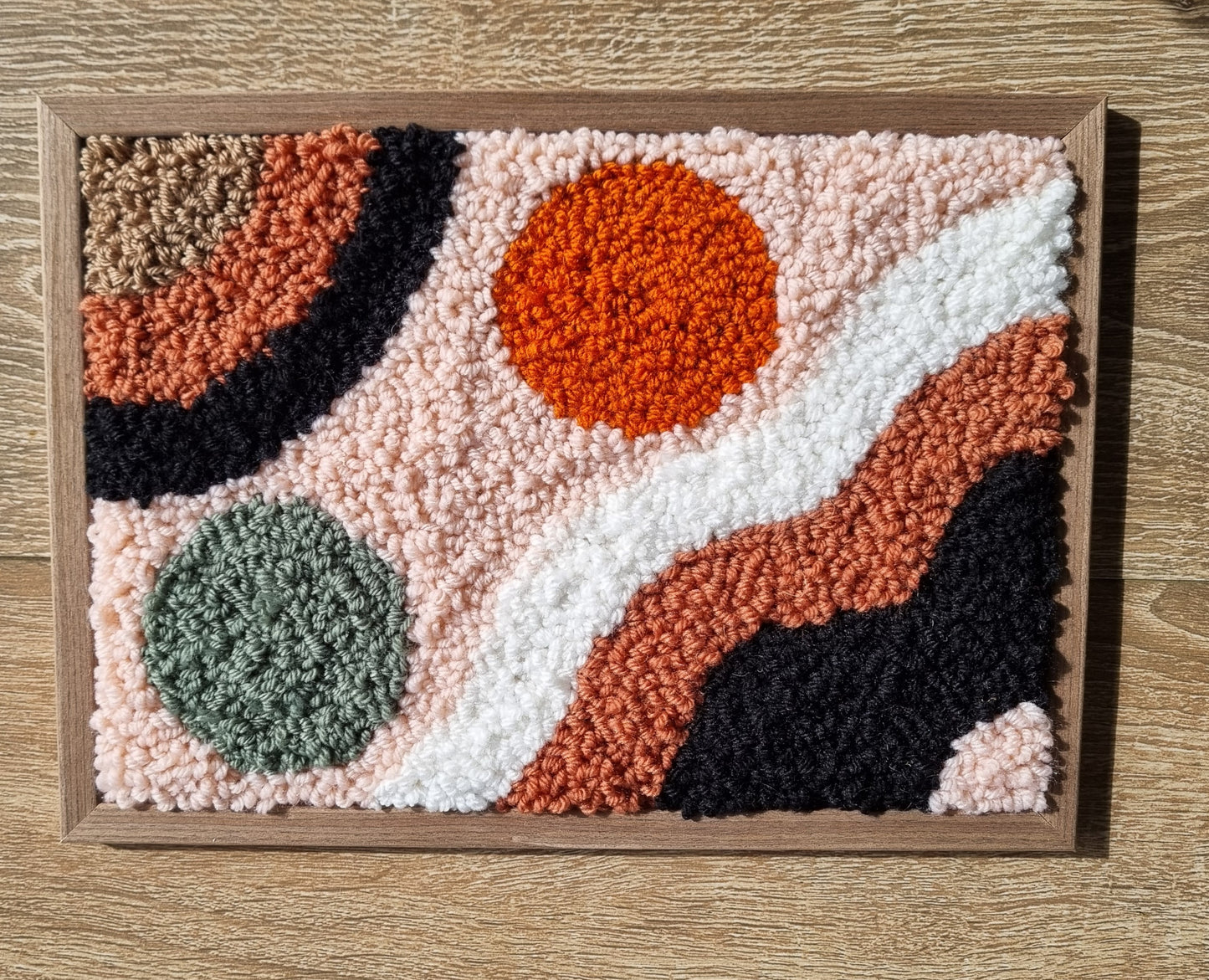 Wall hanging made with punch needle or tufting wool, warm tones of beige, brown, and orange. One-of-a-kind piece, 23 × 31 cm
