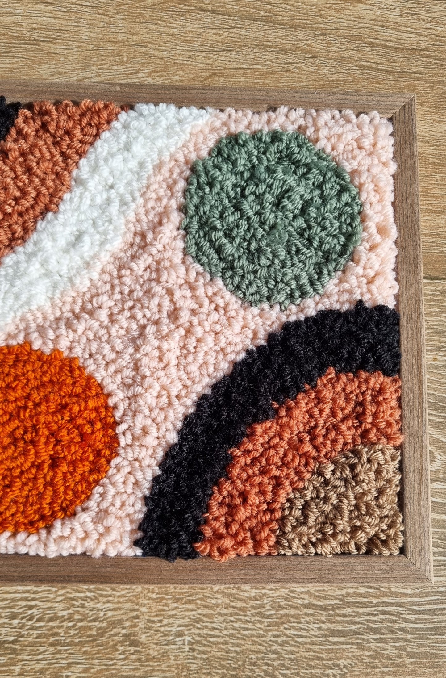 Wall hanging made with punch needle or tufting wool, warm tones of beige, brown, and orange. One-of-a-kind piece, 23 × 31 cm