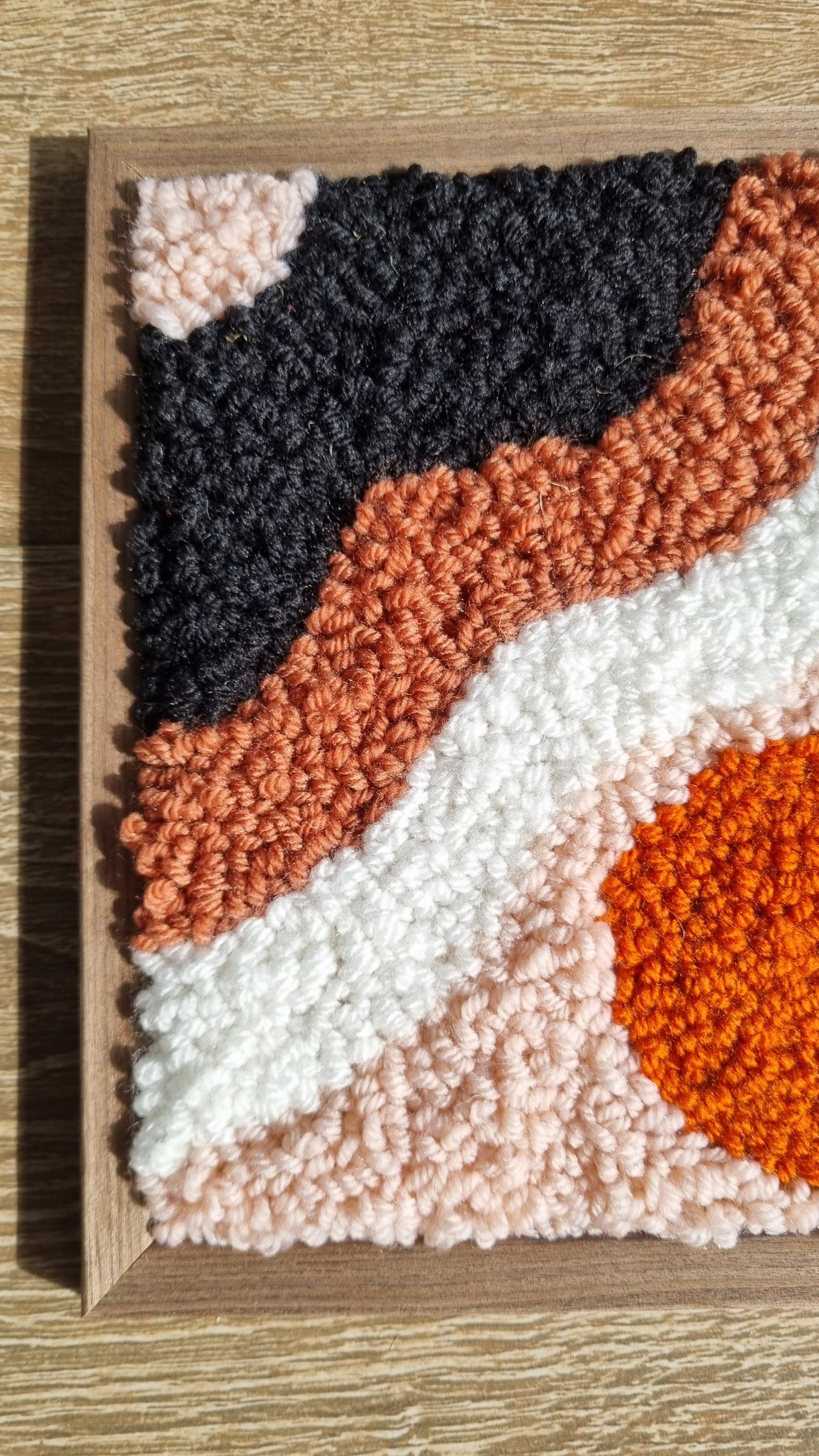 Wall hanging made with punch needle or tufting wool, warm tones of beige, brown, and orange. One-of-a-kind piece, 23 × 31 cm