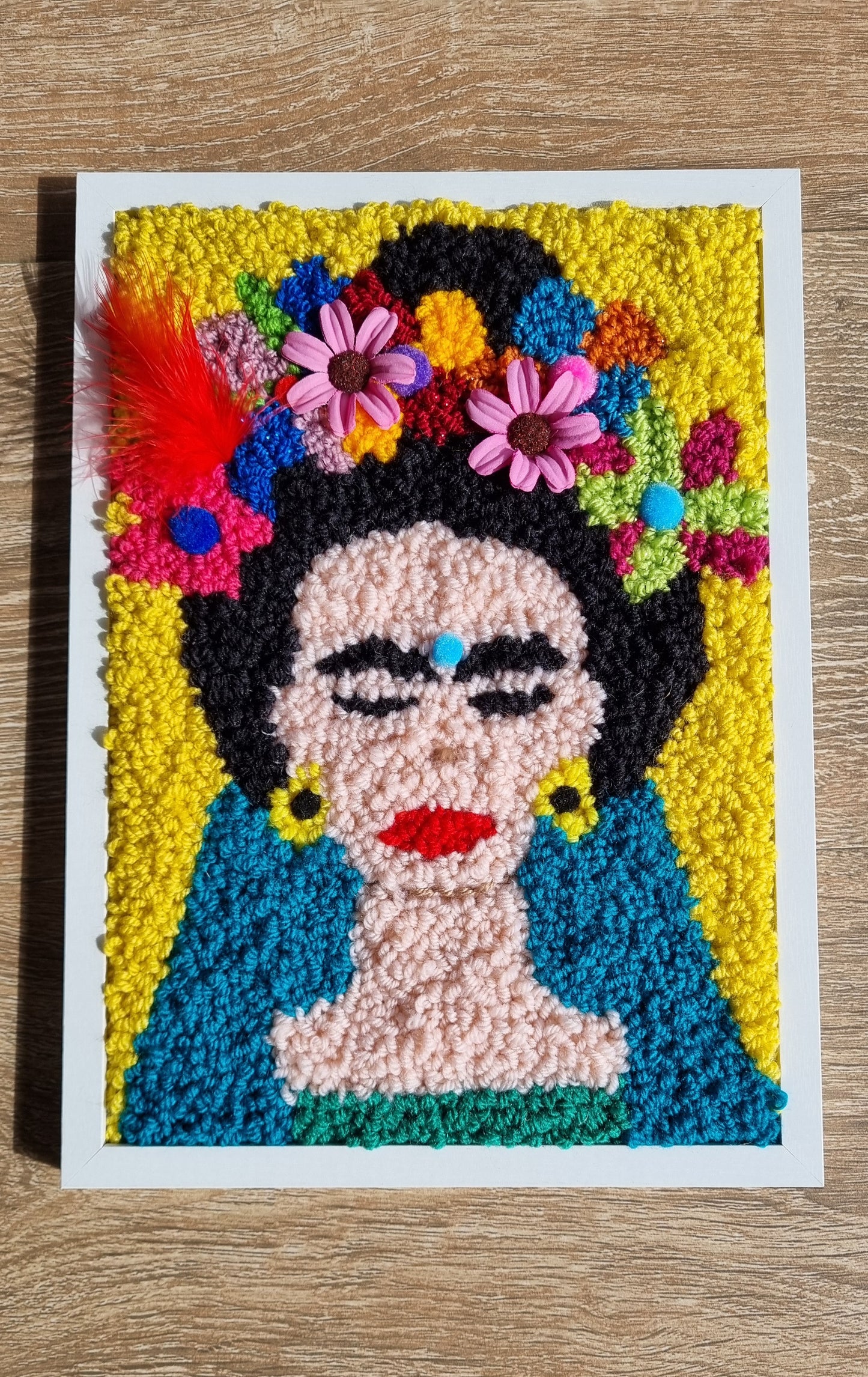 Tableau mural Frida Kahlo en punch needle – Multicolore avec fleurs, pompons et plumes, 23x31 cm, pièce unique