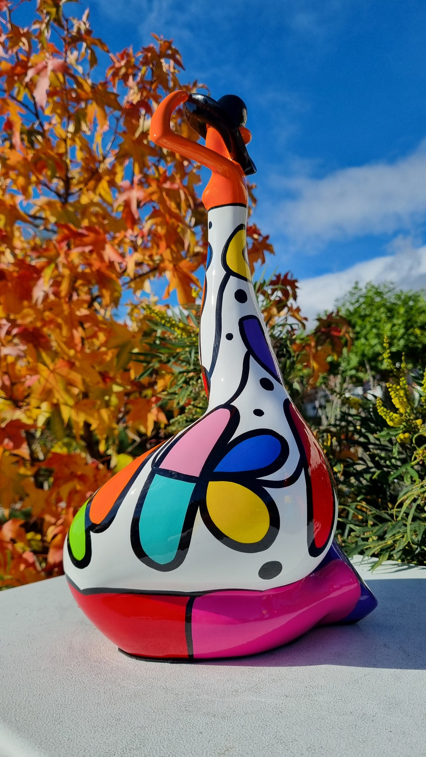 Statue femme contemporaine avec chapeau, en résine orange et multicolore. Hauteur 43 centimètres