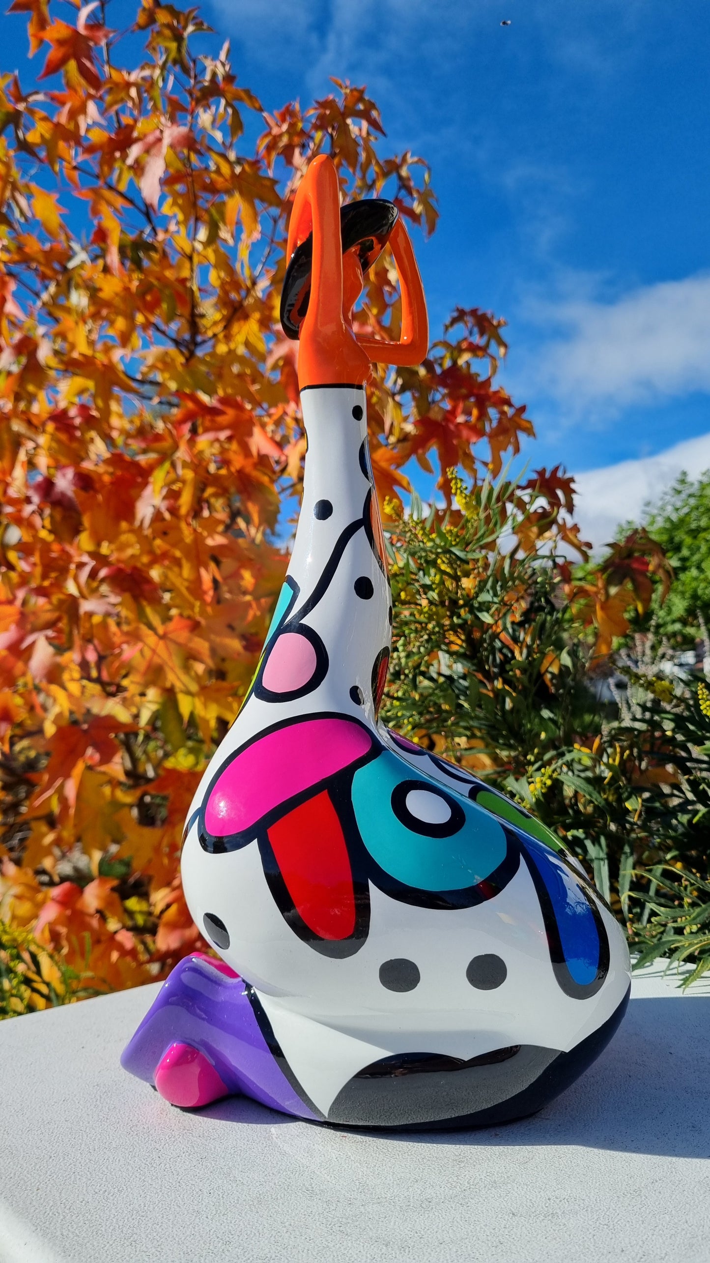 Statue femme contemporaine avec chapeau, en résine orange et multicolore. Hauteur 43 centimètres