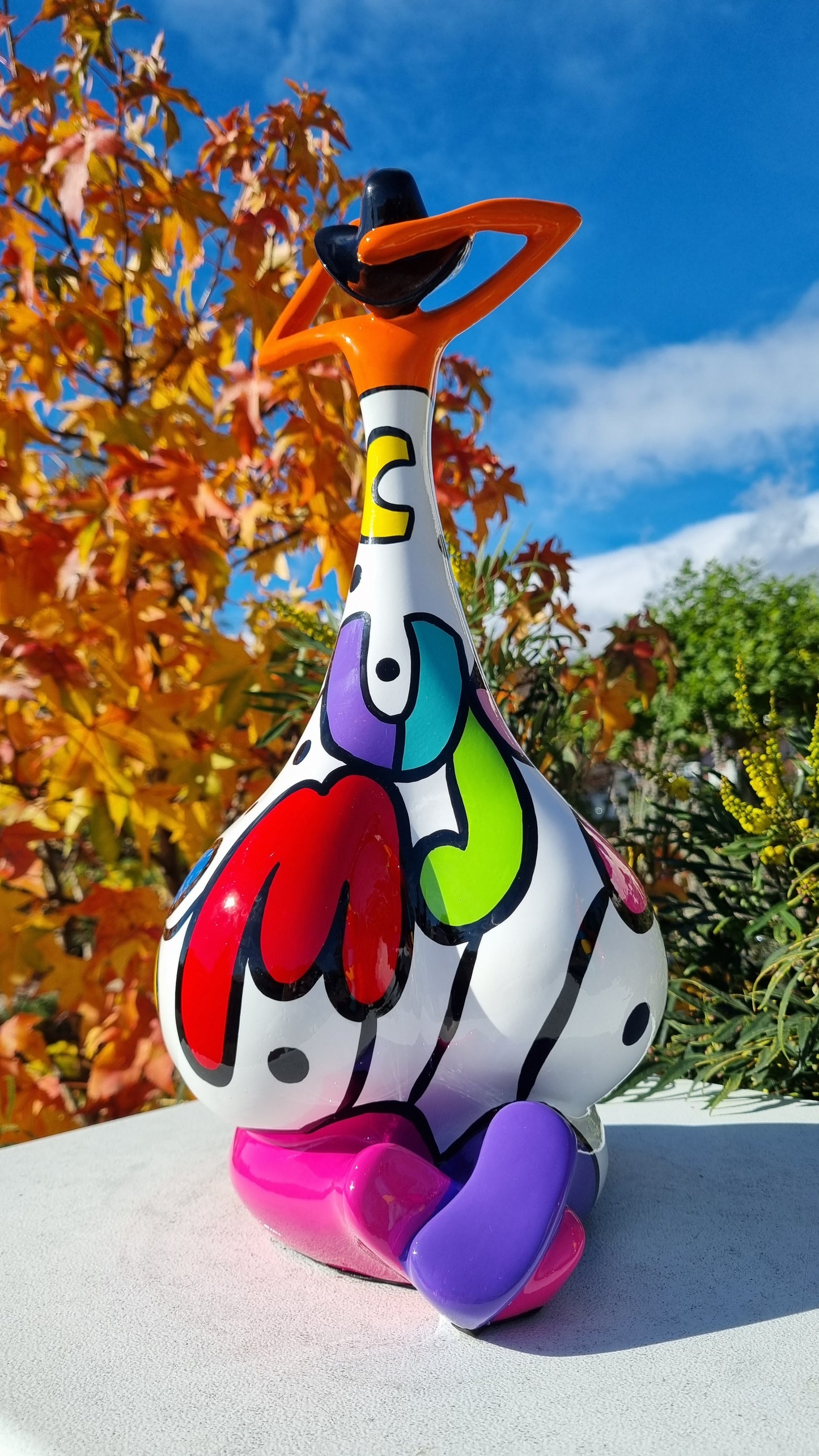 Statue femme contemporaine avec chapeau, en résine orange et multicolore. Hauteur 43 centimètres