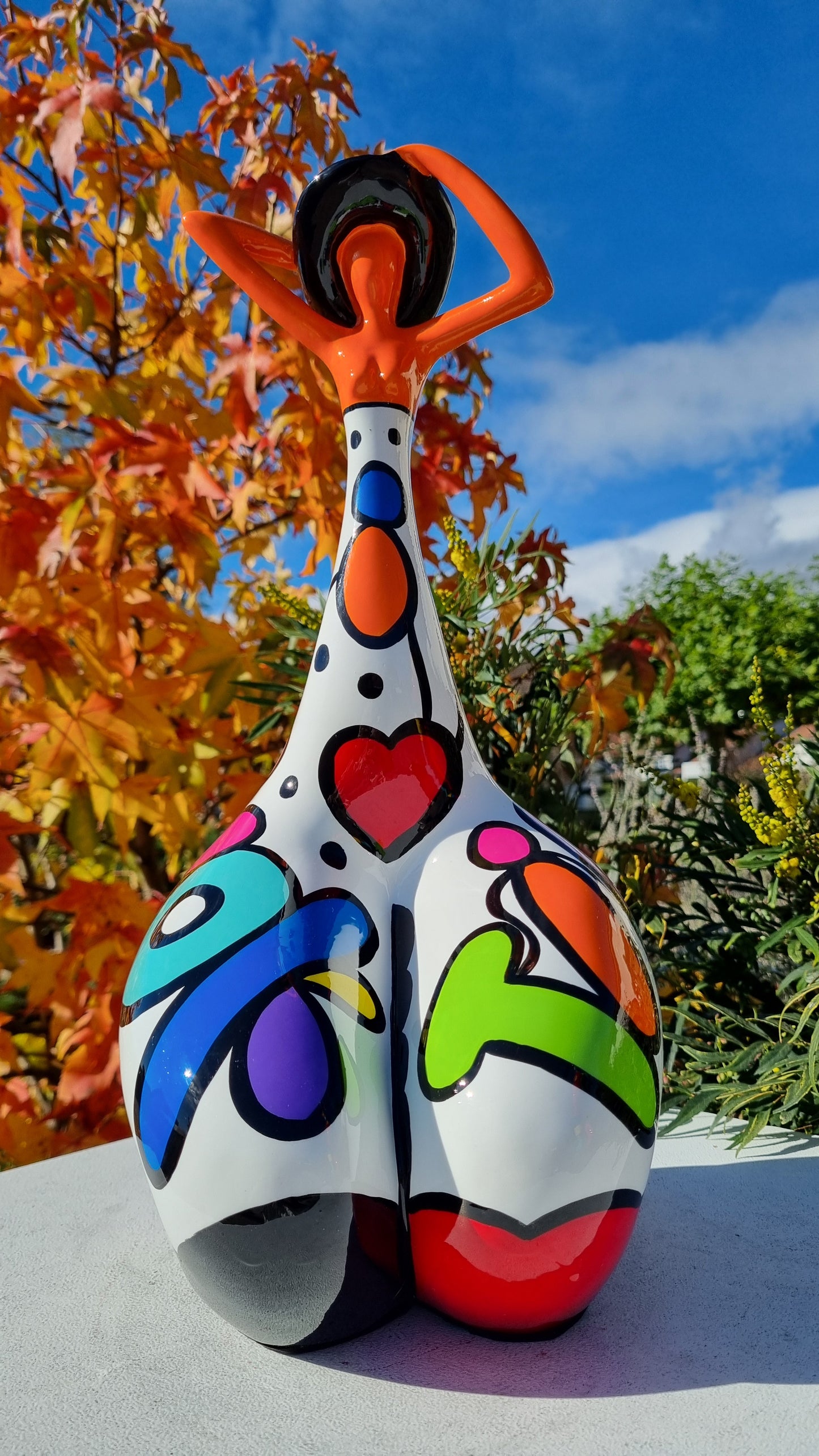 Statue femme contemporaine avec chapeau, en résine orange et multicolore. Hauteur 43 centimètres
